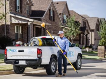 Pest control worker with truck and equipment.